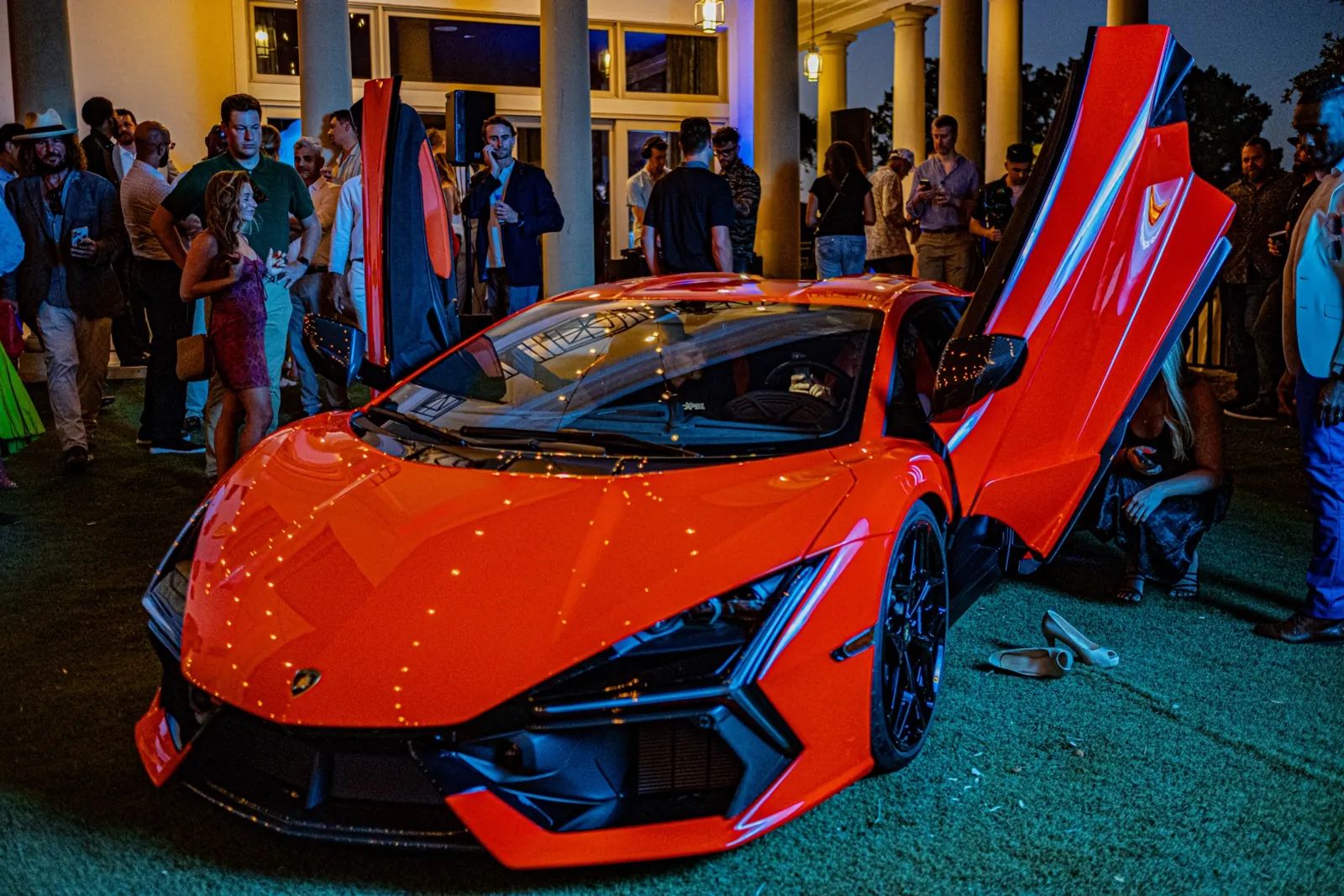 Lamborghini Revuelto with doors open surrounded by guests at the Austin launch party