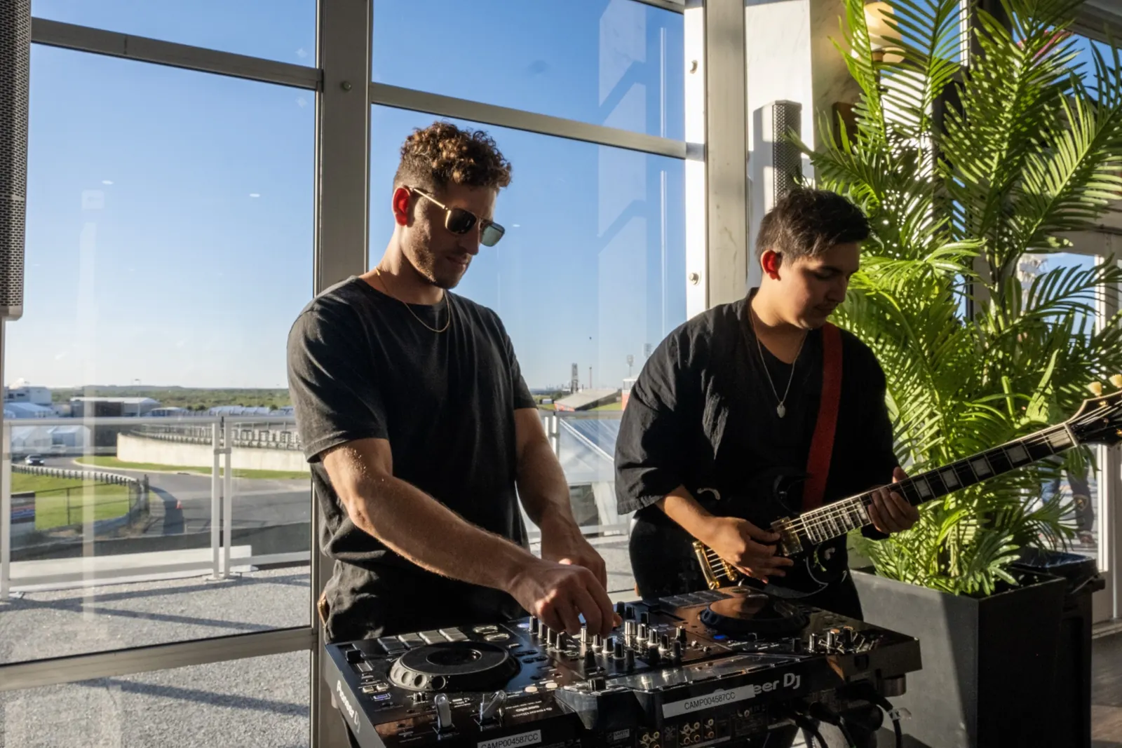 Jordan Miller DJing with a live electric guitarist at an Austin supercar event